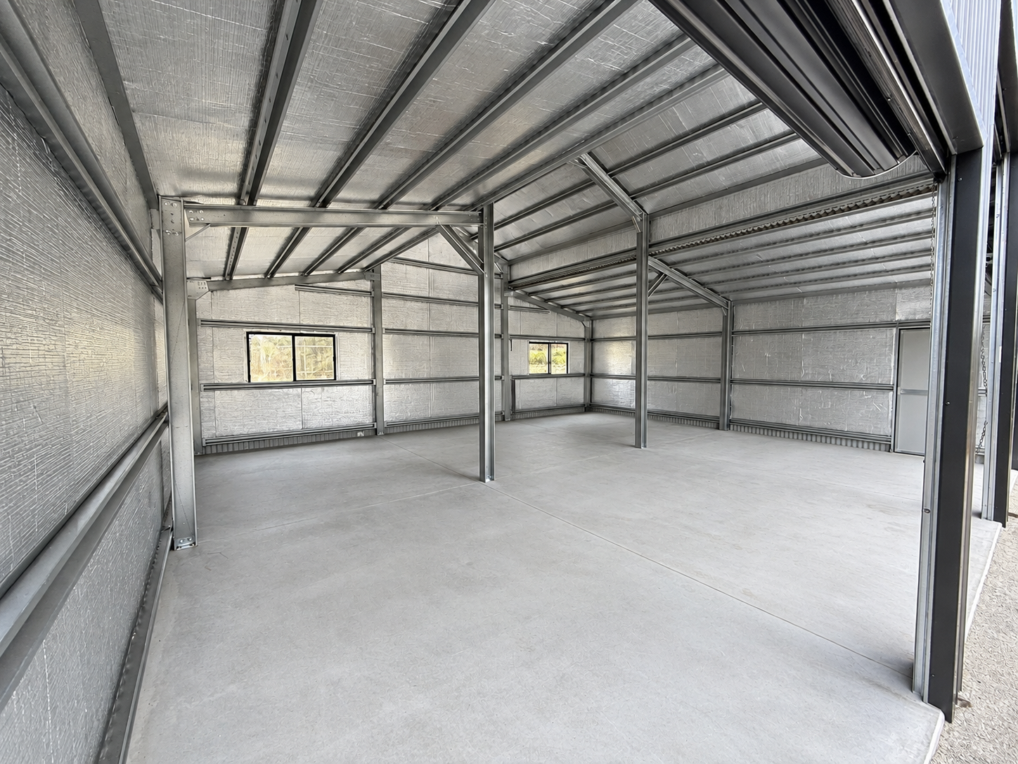 Interior of an insulated barn shed showing steel frame and concrete floor, Tamborine