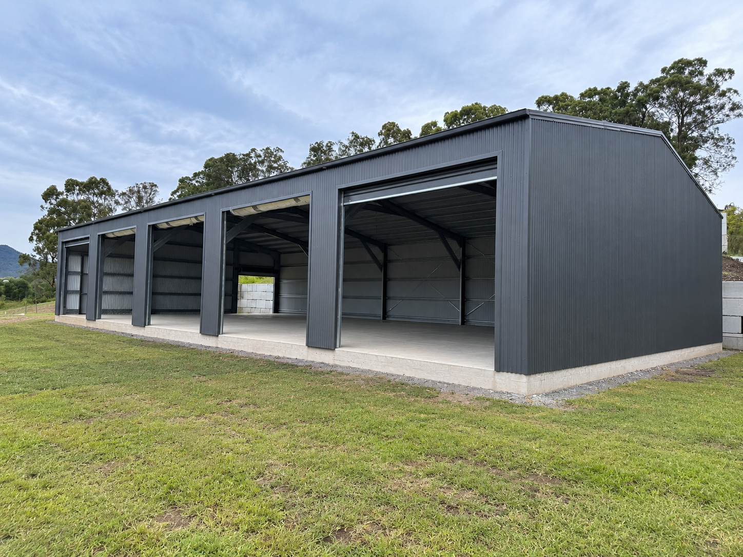 Large custom steel shed with roller doors on a Gold Coast property