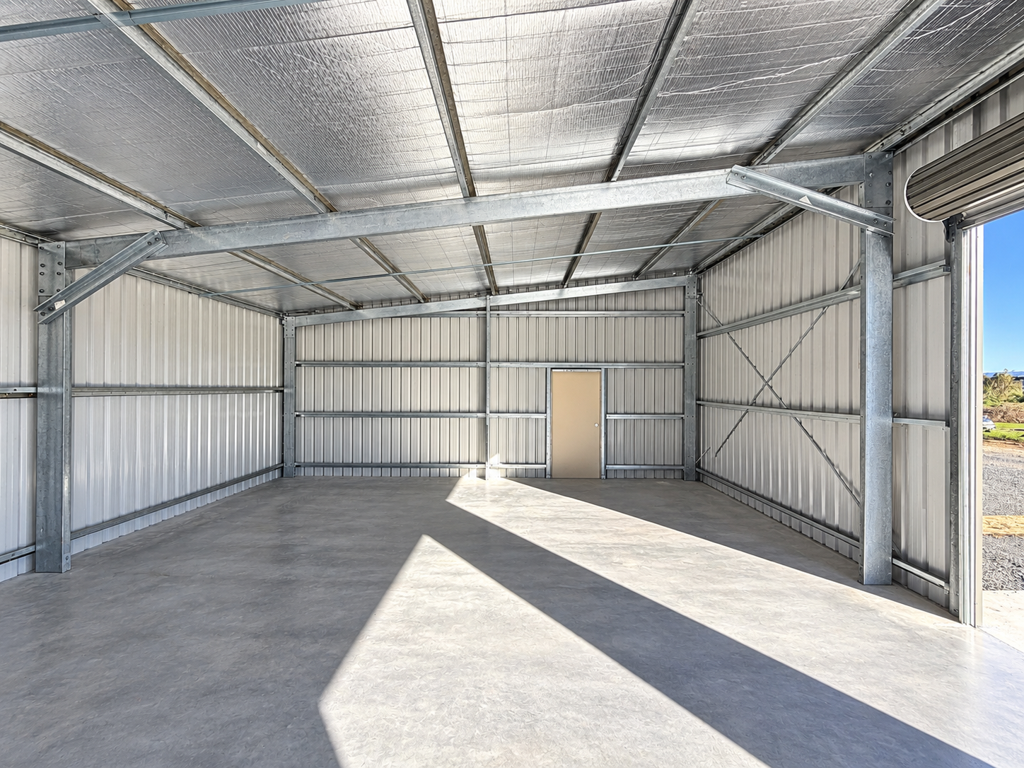 Insulated interior of a steel portal-frame shed showing concrete floor, Brisbane Airport