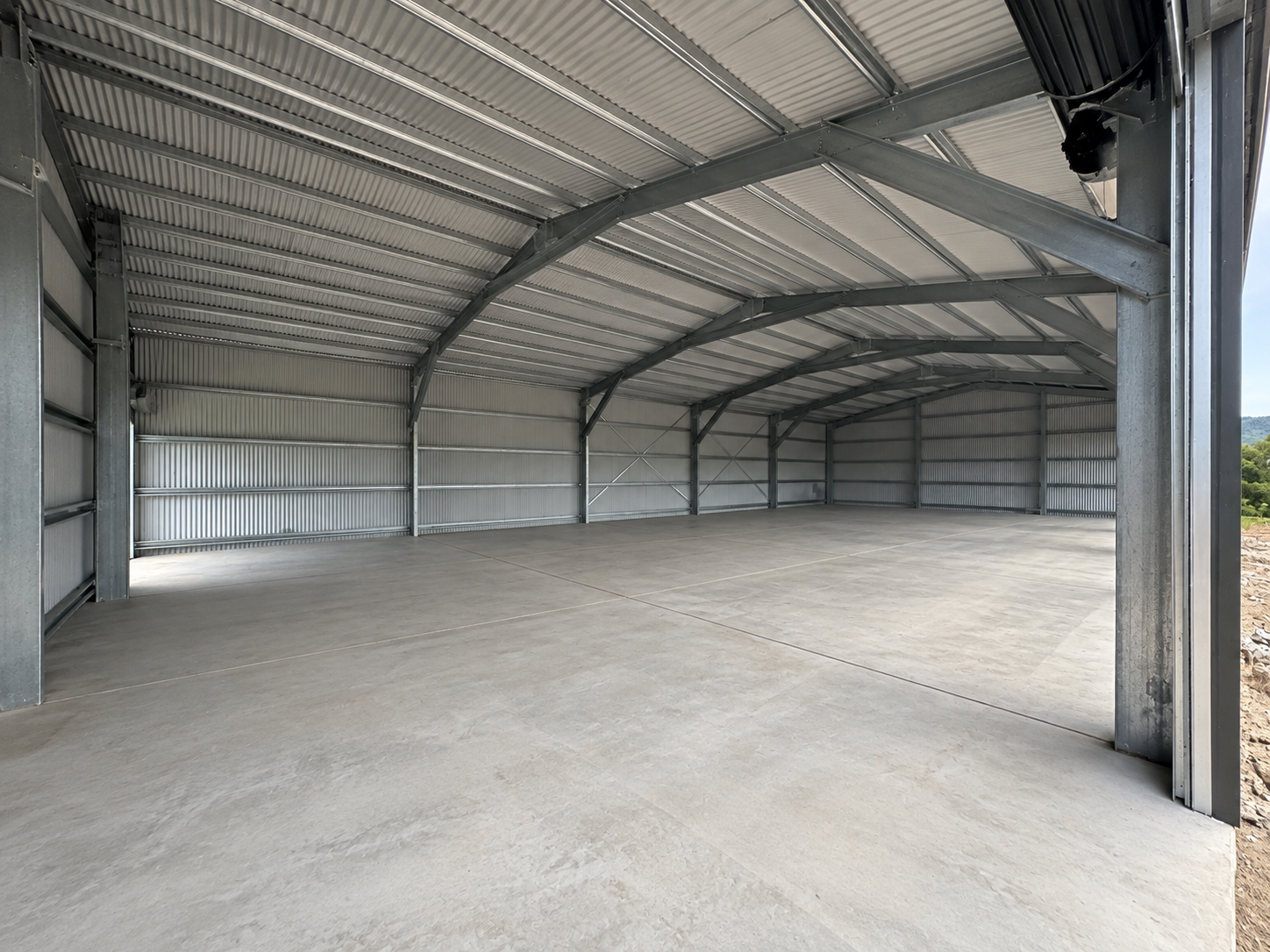 Clear-span interior of a machinery shed with high roofline and open floor space