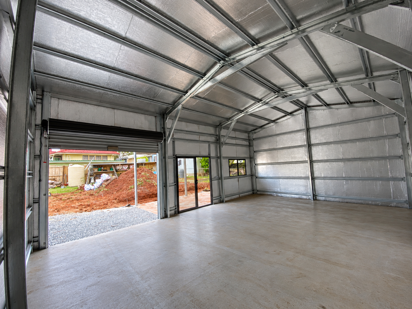 Interior of a 12m x 8m insulated residential shed showing steel frame and roller door, Currumbin